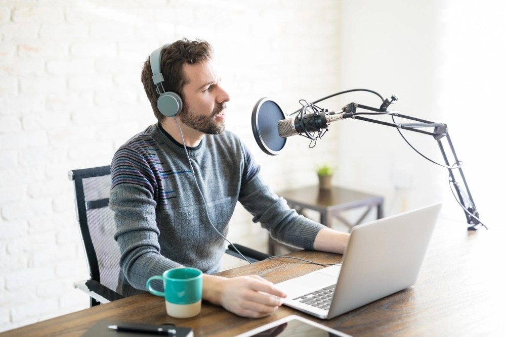People recording a podcast at a table with microphones.